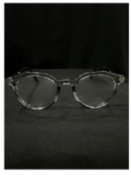 OPTICA clear acetate eyeglasses with subtle gold temple detailing. Round frames with a modern, minimalist style.