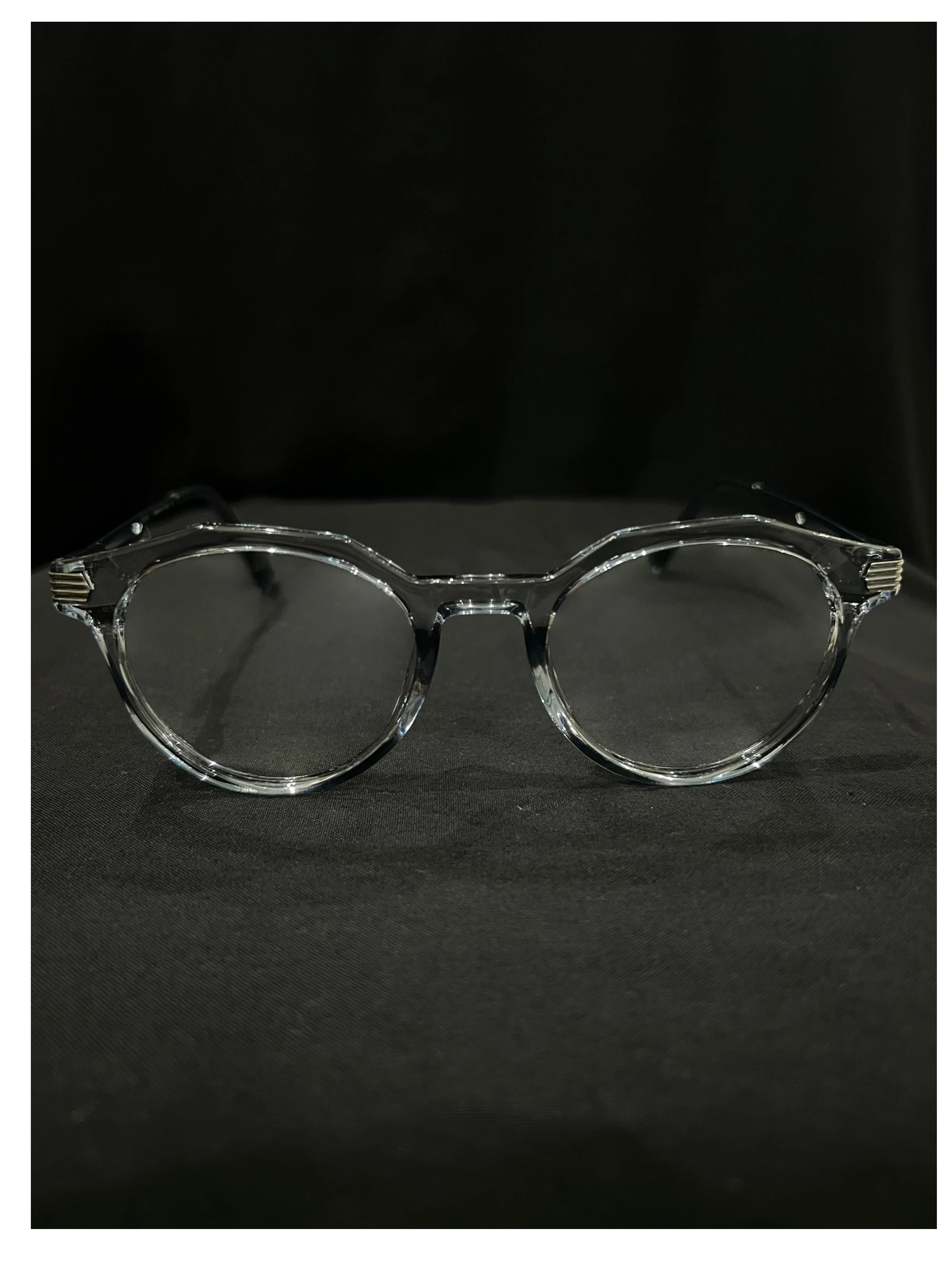 OPTICA clear acetate eyeglasses with subtle gold temple detailing. Round frames with a modern, minimalist style.