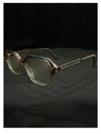 OPTICA geometric octagonal eyeglasses in translucent light brown acetate with angular frames and subtle metallic accents on the temples.