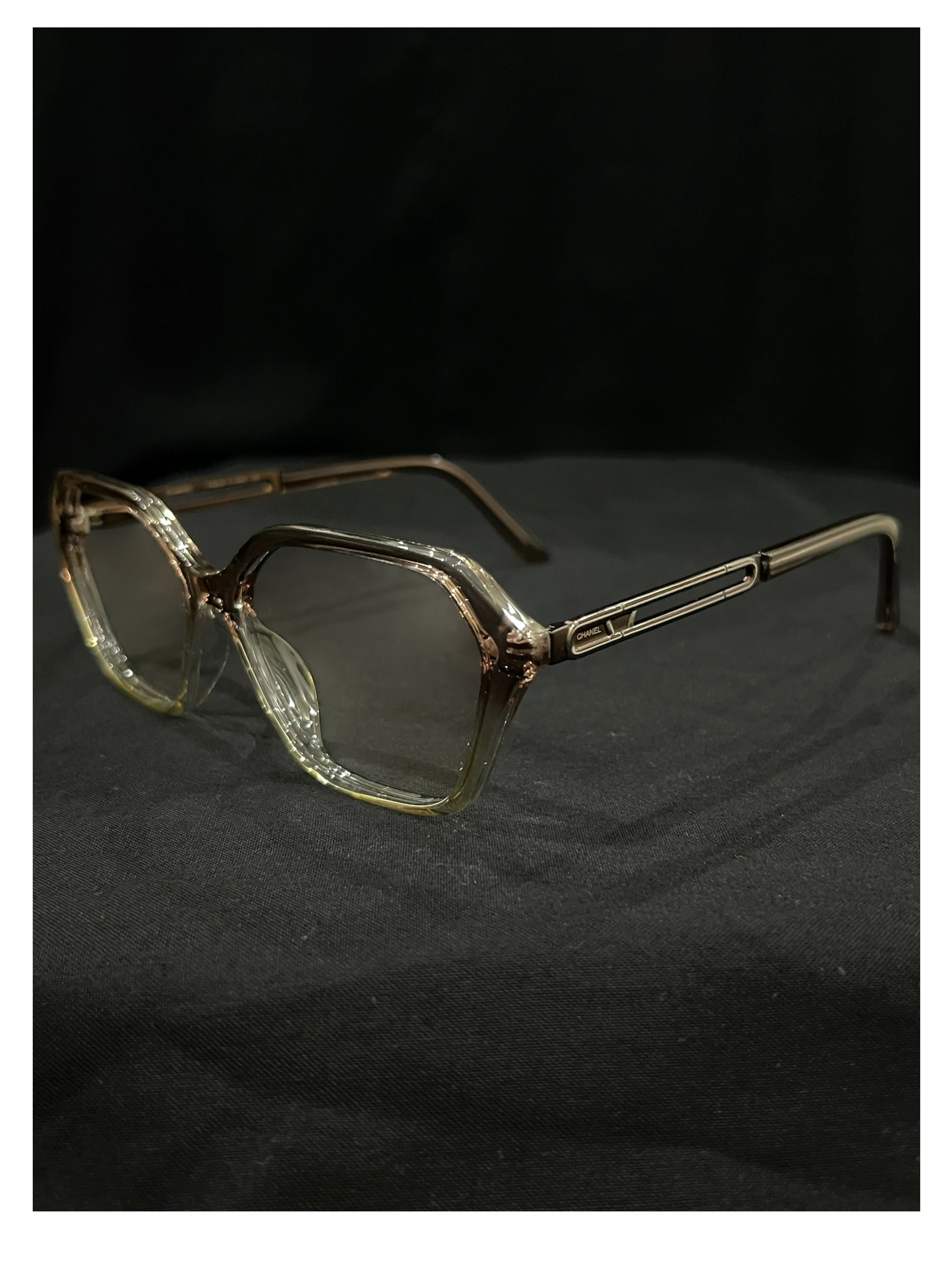 OPTICA geometric octagonal eyeglasses in translucent light brown acetate with angular frames and subtle metallic accents on the temples.