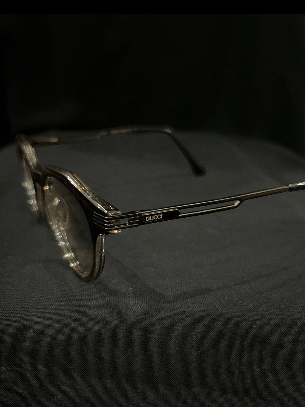 OPTICA Kocka round eyeglasses with black kitty corner accents and Gucci logo on the temples. Clear lenses and a black and white plastic frame.